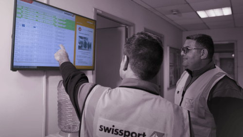 a male swissport employee showing a digital signage screen