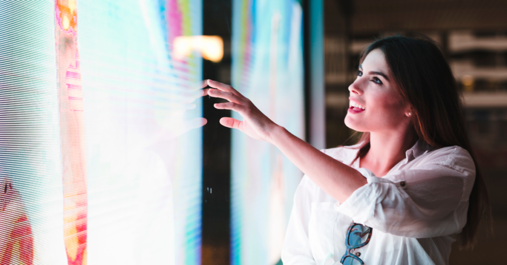 A woman interacts with e digital signage touch screen