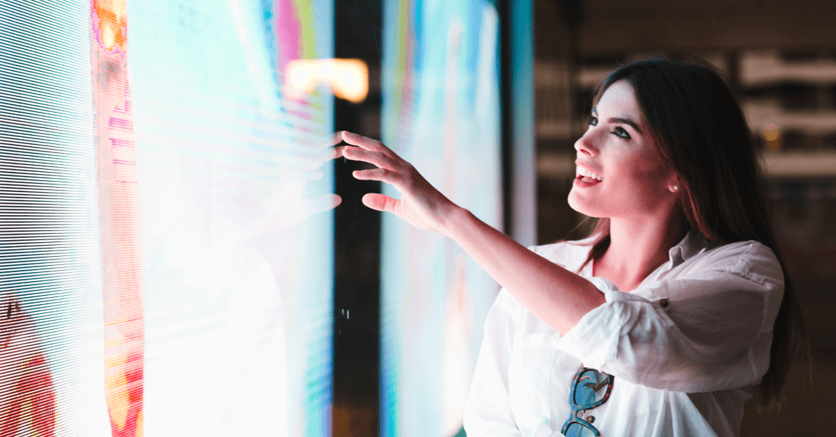 A woman interacts with e digital signage touch screen