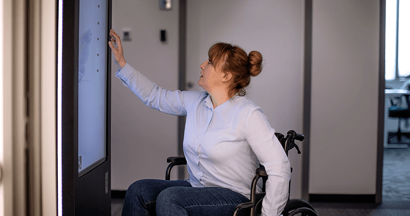 A woman in front of a touchscreen 