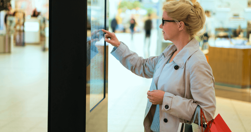 A woman using a touchscreen in a retail shop