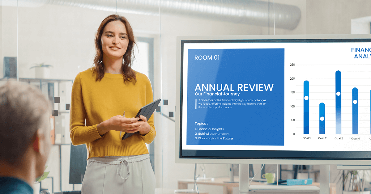 A woman showing the annual review and dashboards on a screen