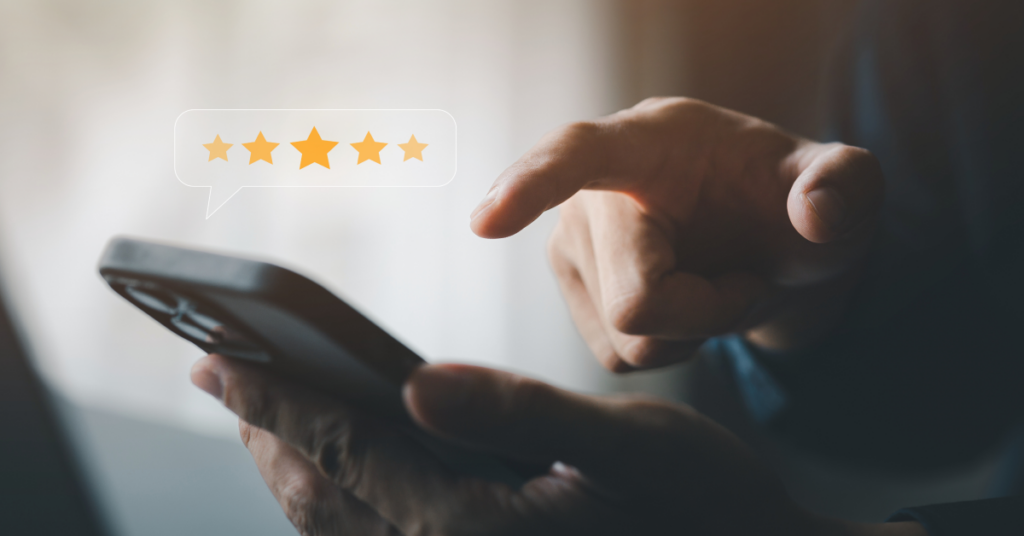 An image of someone's hands giving a 5-star review through the phone